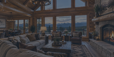 Interior view of a fully furnished, turnkey luxury log cabin in Pagosa Springs featuring a stone fireplace and mountain views.